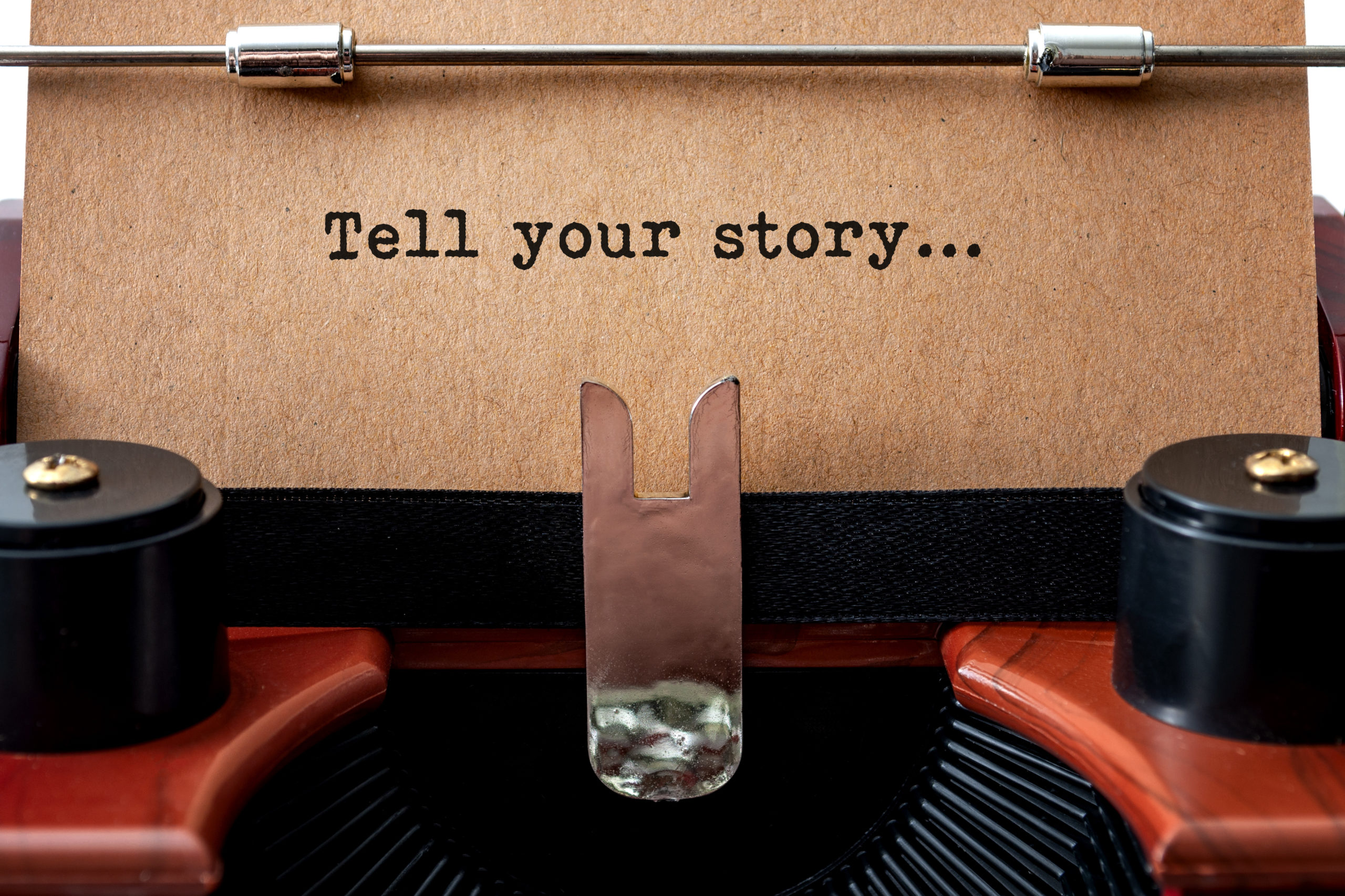 Motivational poster, inspiration to create and storytelling concept with close up on a old typewriter and the text - tell your story - on vintage brown paper